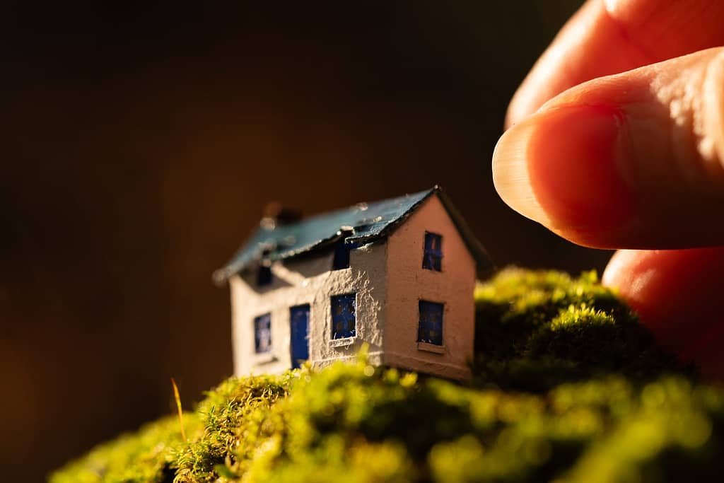 A micro miniature diorama of a coastal cottage placed on moss