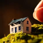 A micro miniature diorama of a coastal cottage placed on moss