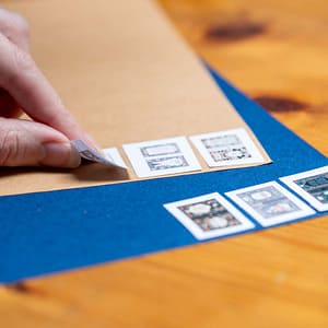 Glueing printed miniature book covers to brown and blue colored card stock