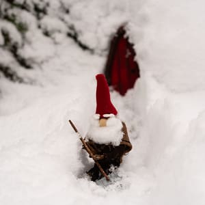 gnome shovelling snow Gnome with a red pointy hat using a snow shovel to clear a path in front of his door
