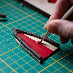 red paint on fairy door A triangular fairy door being painted red
